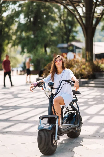 Jonge mooie vrouw en een elektrische scooter, ecologisch transport — Stockfoto