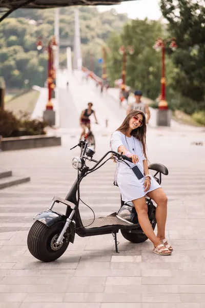 Jonge mooie vrouw en een elektrische scooter, ecologisch transport — Stockfoto
