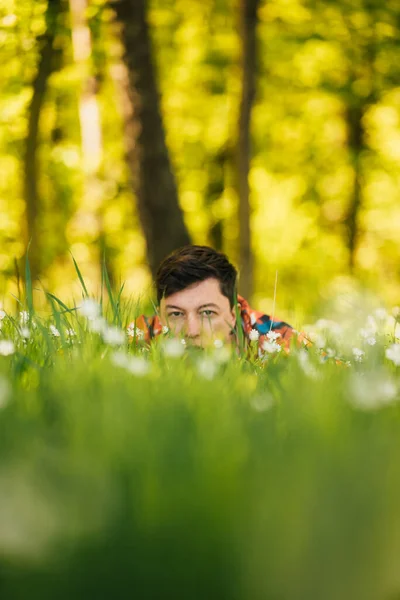 Jovem escondido na grama verde — Fotografia de Stock