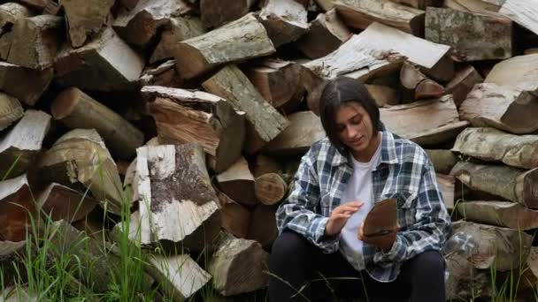 Kobieta w lesie w pobliżu bieguna siekanego drewna — Wideo stockowe