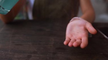 Karantina sırasında el dezenfektanı sıkan genç bir kadın..