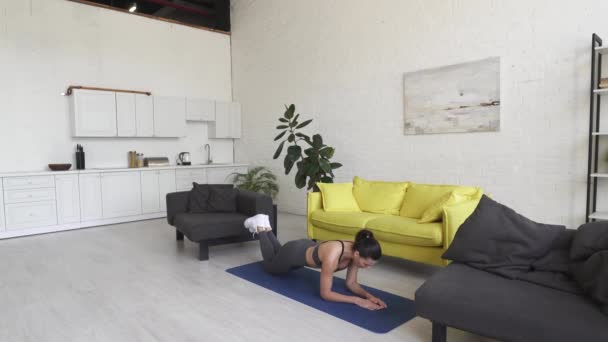 Piękna młoda kobieta robi ćwiczenia na podłodze w domu — Wideo stockowe