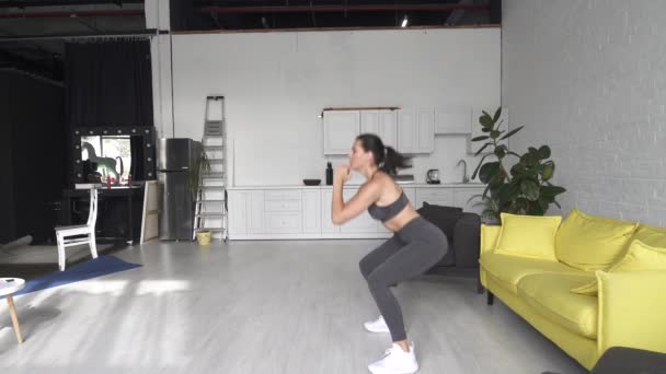 Vacker ung kvinna gör fitness hemma — Stockvideo