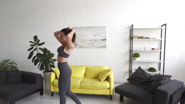 Красивая молодая женщина делает упражнения брюшной полости в комнате — стоковое видео