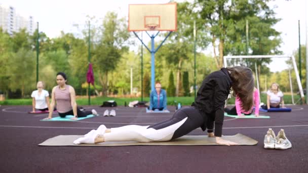 Motivated fit yoga coach doet oefeningen op mat outdoor — Stockvideo