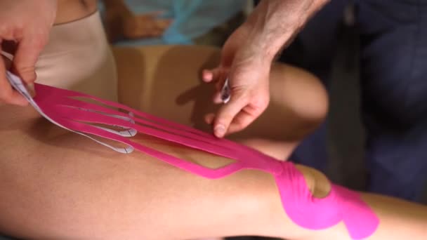 Fisioterapista che applica il nastro kinesio sulla paziente femminile. — Video Stock
