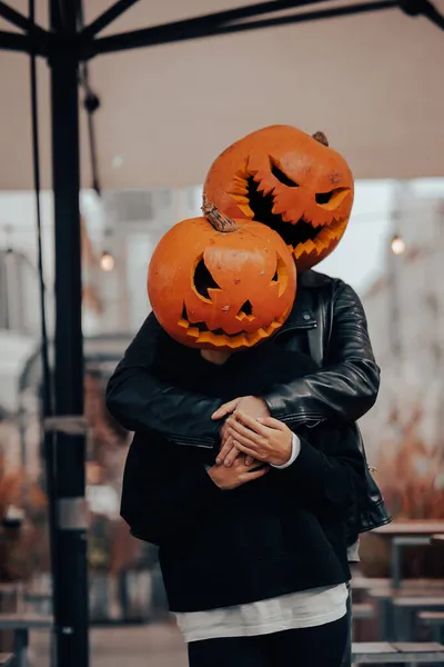 A guy and a girl with a pumpkin heads posing on the street — Stock Photo, Image