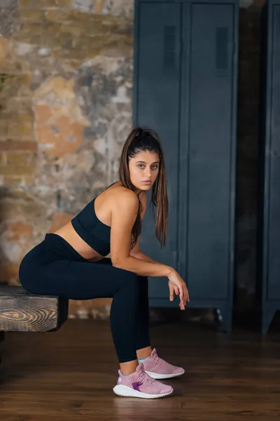 Mujer deportiva en ropa deportiva descansando en el banco en la aptitud. —  Fotos de Stock