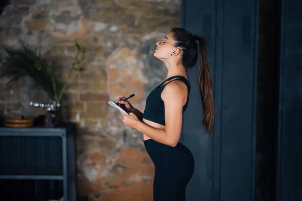 Jonge vrouwen schrijven iets op in het notitieboekje.. — Stockfoto