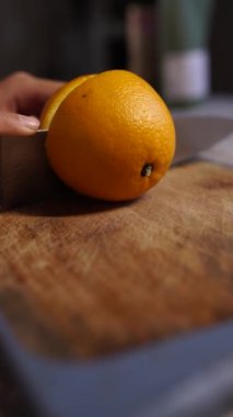 Bayanlar taze turuncu mutfak üzerinde kesme eller