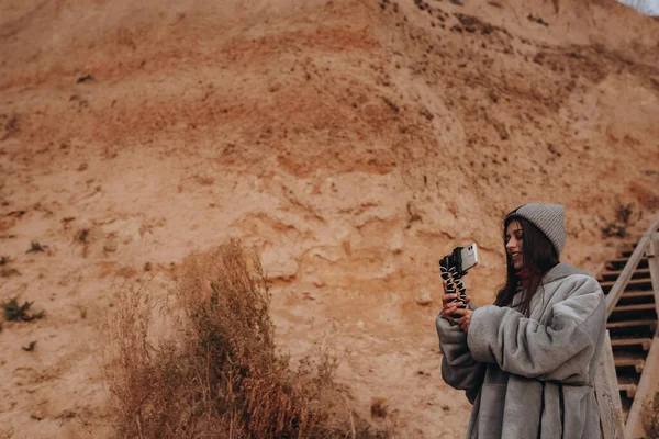 Jovem tira uma foto em um smartphone da paisagem marinha — Fotografia de Stock