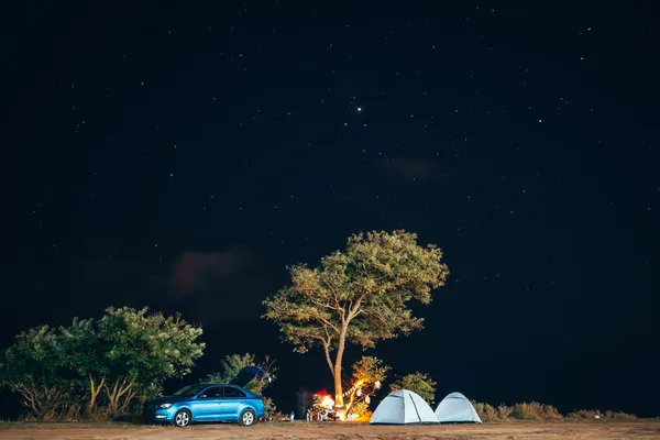 Група з п'яти мандрівників відпочиває на морському березі на фоні вечірнього неба . — стокове фото