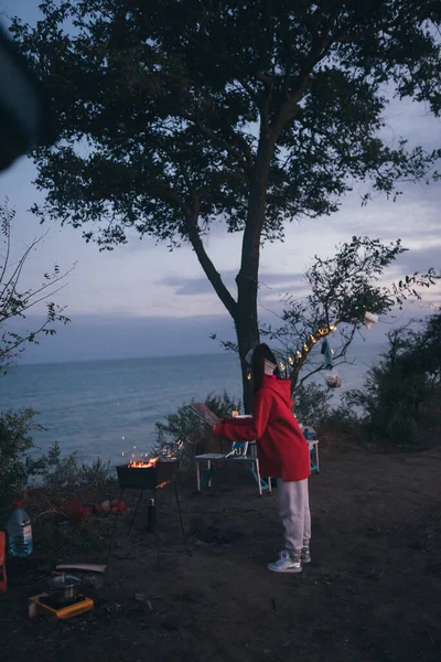 Jeune femme préparant la nourriture sur le gril au bord de la mer — Photo