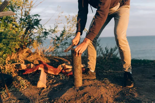 Mann hackt an einem sonnigen Tag Holz mit einem großen Lagerfeuer-Messer. — Stockfoto