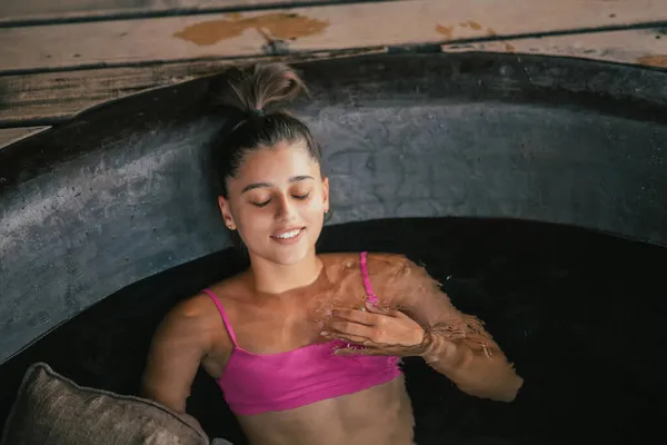 Женщина отдыхает в круглой ванне. Органический уход за кожей в горячей ванне — стоковое фото