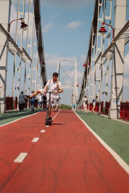 Günlük kıyafetli bir adam bir e-scooter kiraladı ve eğleniyor.