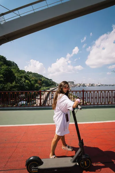 Jonge mooie vrouw en een elektrische scooter, ecologisch transport — Stockfoto