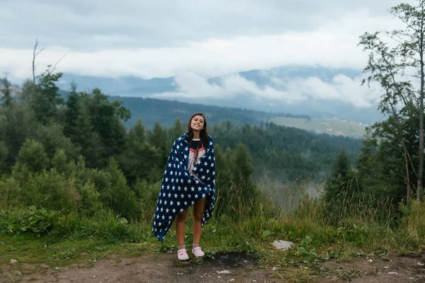 Kvinna som står på toppen av en kulle, mot bakgrund av en dal — Stockfoto