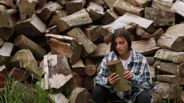 Женщина в лесу рядом с полюсом из рубленного дерева — стоковое видео