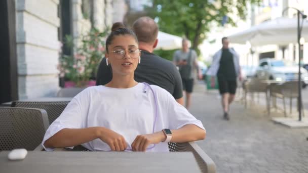 ストリートカフェに座っている美しい若い女性 — ストック動画