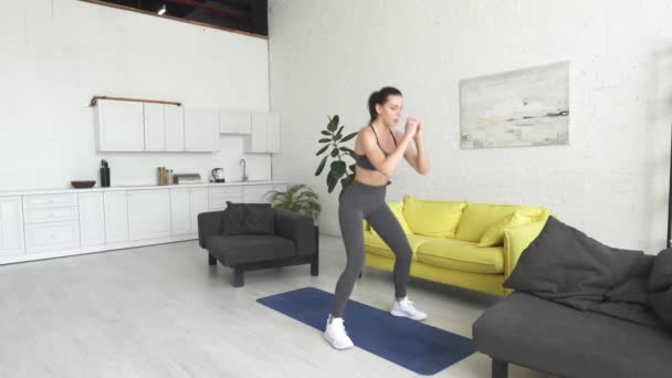 Hermosa joven haciendo ejercicio en casa — Vídeos de Stock