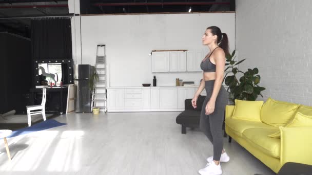 Vacker ung kvinna gör fitness hemma — Stockvideo