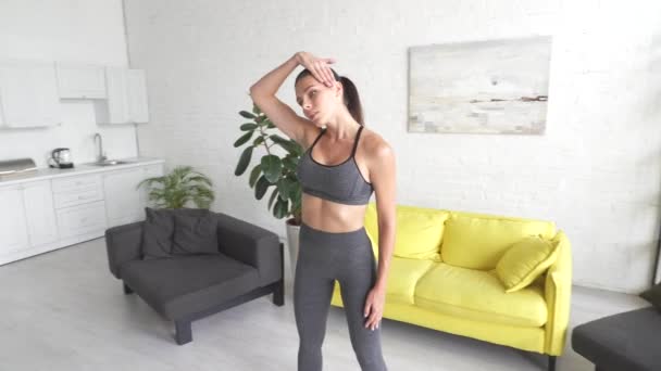Wanita muda yang cantik melakukan latihan perut di kamar — Stok Video