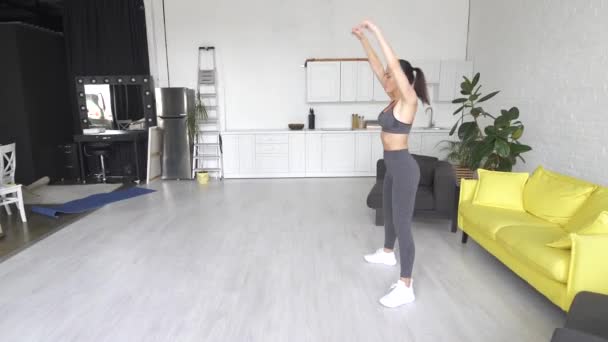 Όμορφη νεαρή γυναίκα κάνει κοιλιακές ασκήσεις στο δωμάτιο — Αρχείο Βίντεο