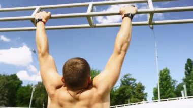 Güçlü bir adam açık hava spor salonuna yanaşıyor..