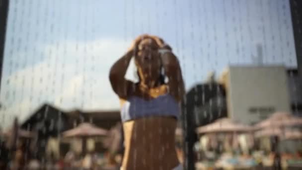 Schöne Mädchen in Badebekleidung Duschen unter Wasser am Resort Beach. — Stockvideo