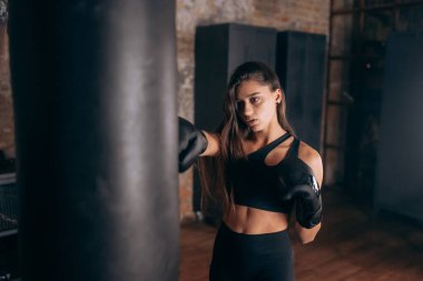 Spor salonunda boks yapan genç bir kadın.