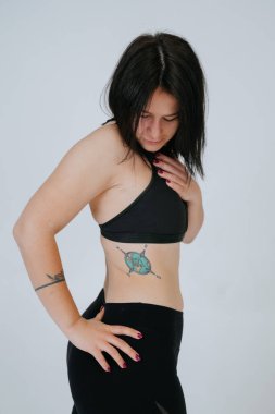 Sıradan bir genç kadın beyaz bir arkaplana tepeden bakar. Vücut pozitif konsept.