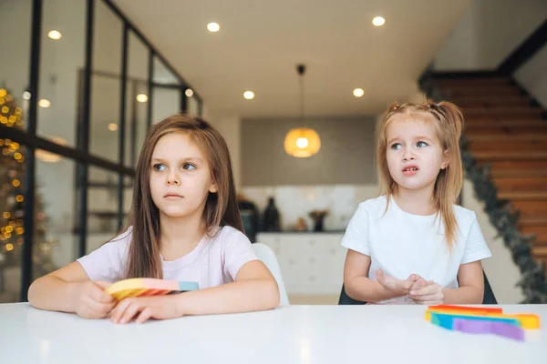 Foto von zwei kleinen Mädchen, die am Tisch vor der Kamera spielen — Stockfoto