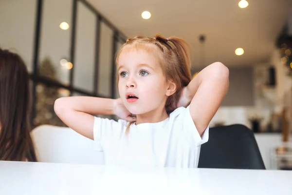 Porträt eines kleinen, überraschten Mädchens im weißen Kleid — Stockfoto