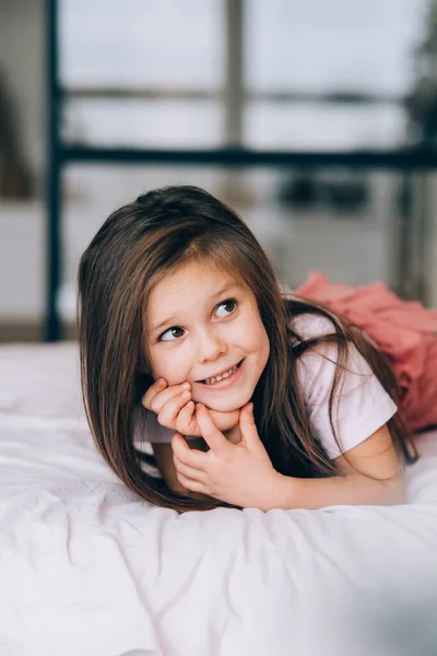 Kleines Mädchen liegt im Bett und schaut weg. — Stockfoto