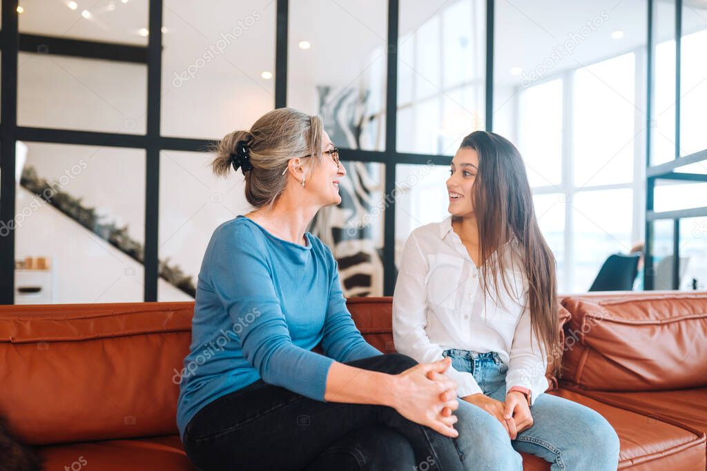 Young woman visiting grandmother at home, women talk