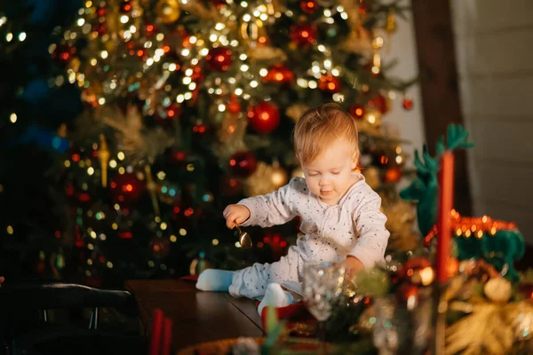 En liten gutt som leker ved juletreet. – stockfoto