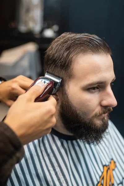 Master in barbershop makes mens haircutting with hair clipper — Stock Photo, Image