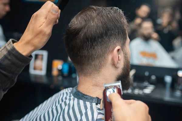 Master in barbershop makes mens haircutting with hair clipper — Stock Photo, Image