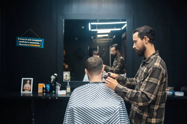 Mestre em barbearia faz homens corte de cabelo com cortador de cabelo — Fotografia de Stock