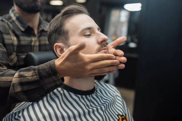 Facial applicare lozione dopo la rasatura nel negozio di barbiere. — Foto Stock
