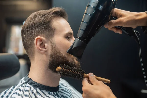 O mestre na barbearia está denominando o cabelo dos clientes — Fotografia de Stock