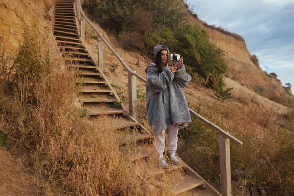 Молода жінка робить фото на смартфоні морського пейзажу — стокове фото