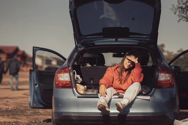 Attraktive junge Frau ruht im Kofferraum eines Autos — Stockfoto