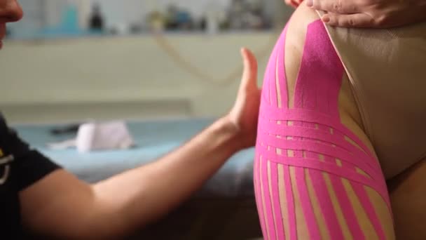여성 환자에게 크레 노시오 테이프를 사용하는 물리 치료사. — 비디오