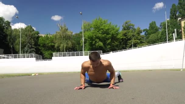 Strong man doing push ups in outdoor street gym. — 图库视频影像