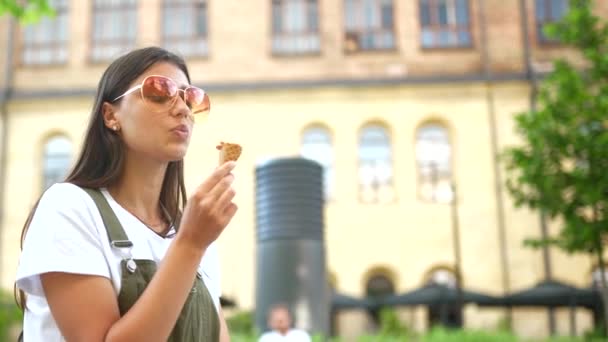 Szépség fiatal boldog nő a parkban, eszik fagylaltot, élvezi az életet nyári szünidő — Stock videók