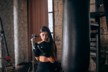 Spor salonunda boks yapan genç bir kadın.