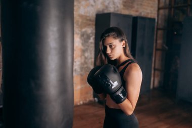 Spor salonunda boks yapan genç bir kadın.