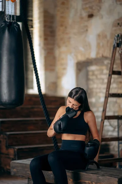 Bela jovem fitness menina tirando uma luva de boxe — Fotografia de Stock